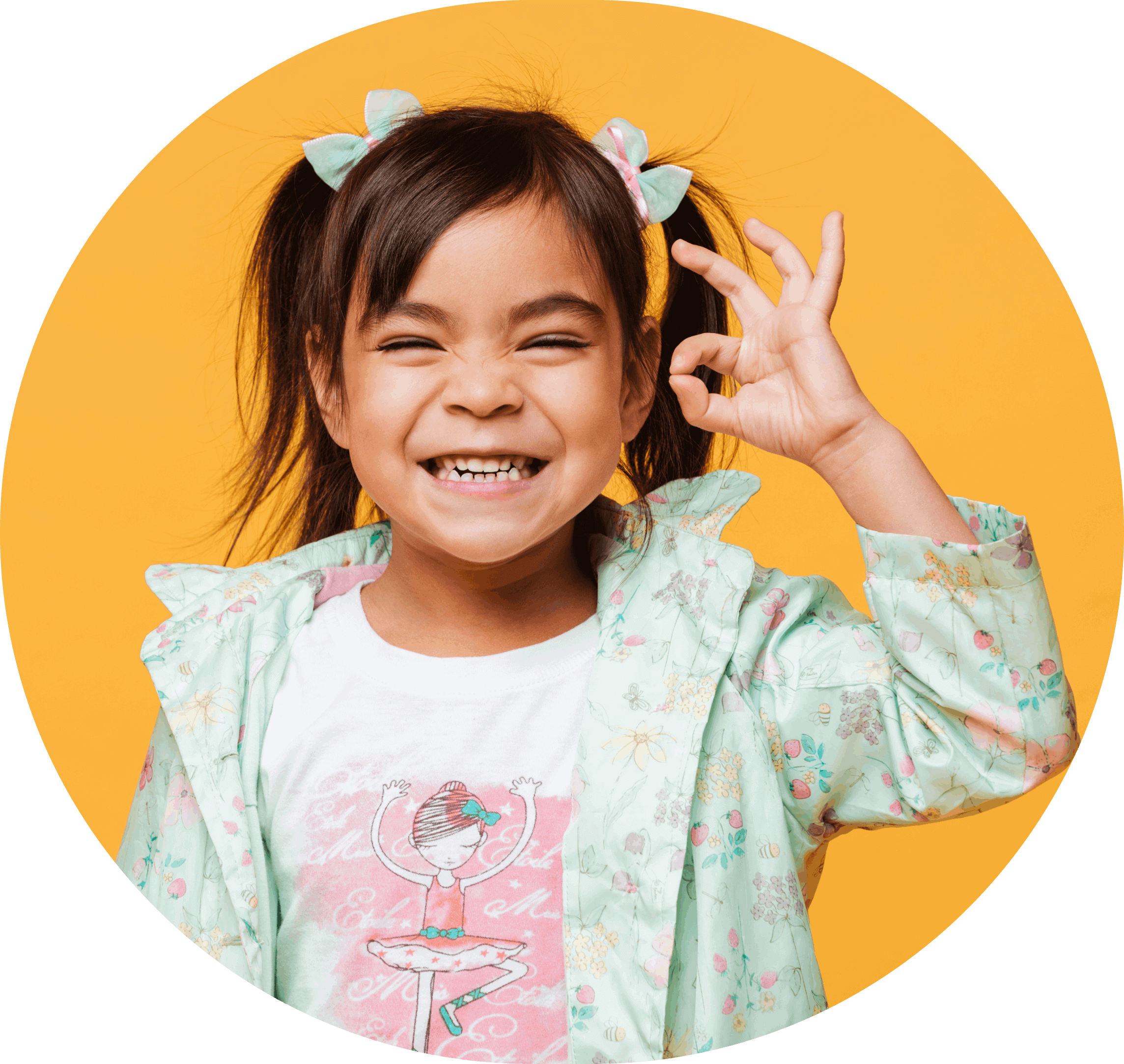 Child smiling and making okay symbol with her hand